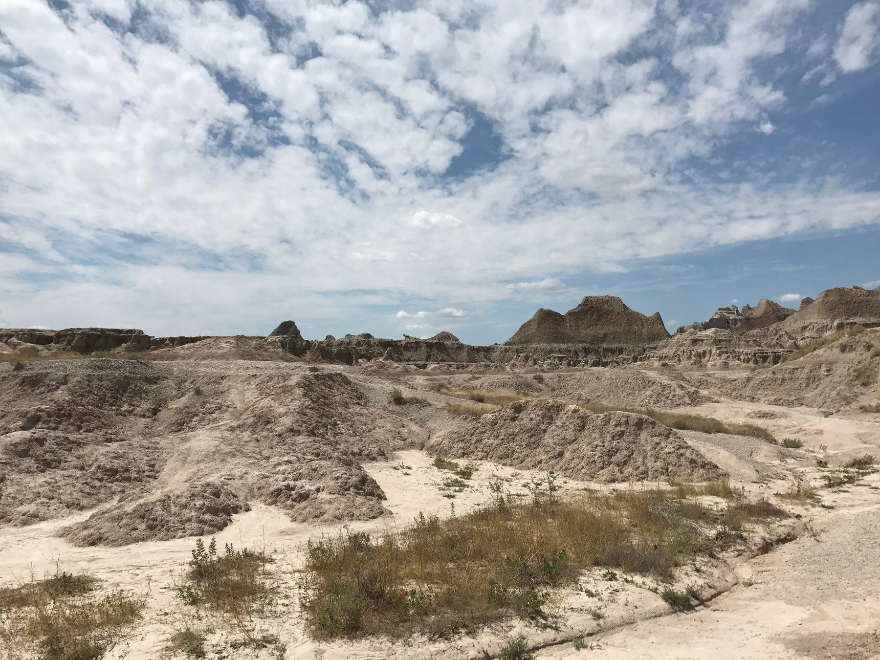 Wide Badlands landscape under a dramatic cloud-filled sky